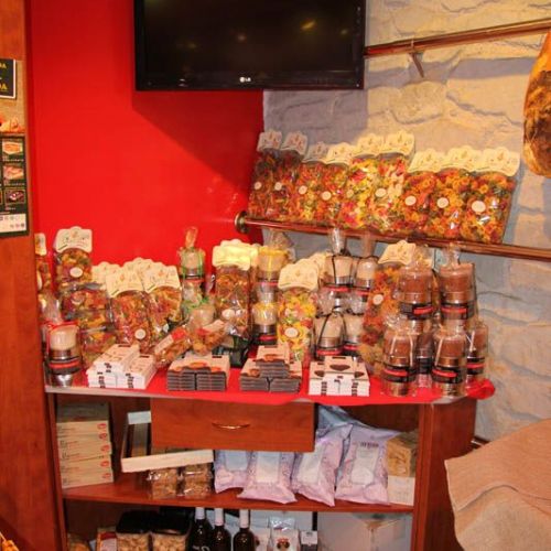 Imagen de interior de la tienda en color granate con expositor de productos gourmet